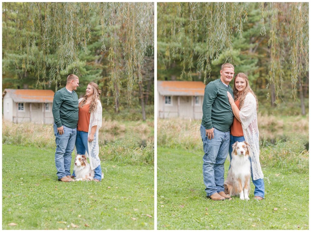 couple posing together with their dog outside for fall photos