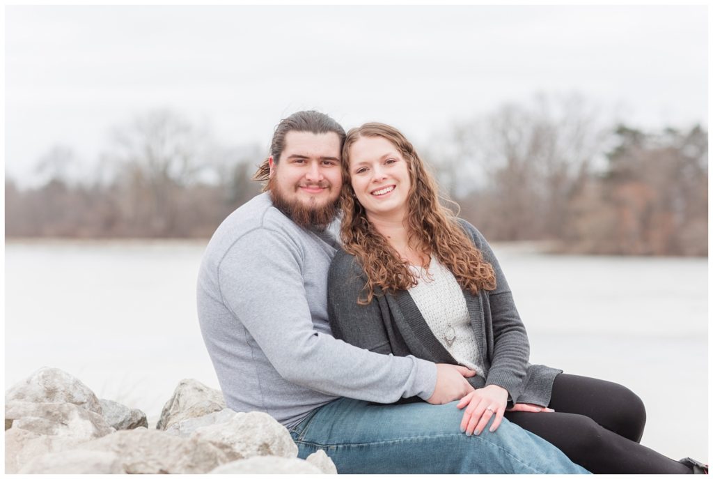 couple sitting together on rocks looking at the camera during engagement session in Ohio