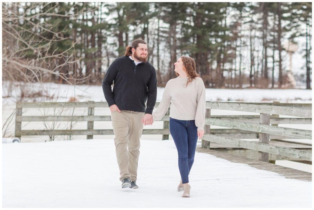 couple walking together in snow for engagement photos