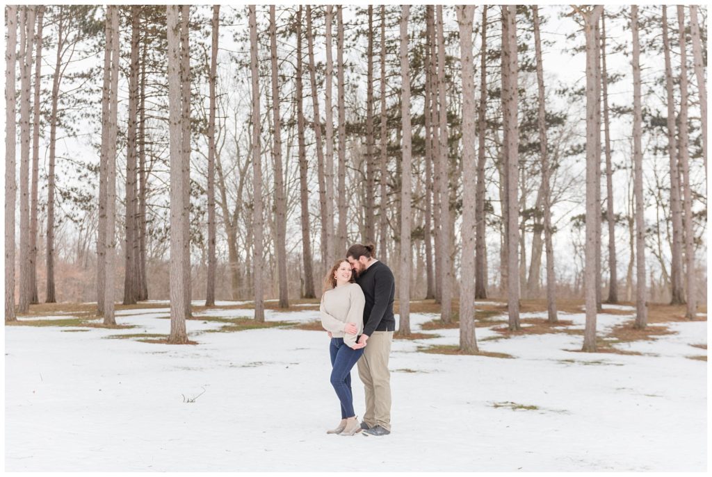 couple posing in front of brown trees and snow in Ohio