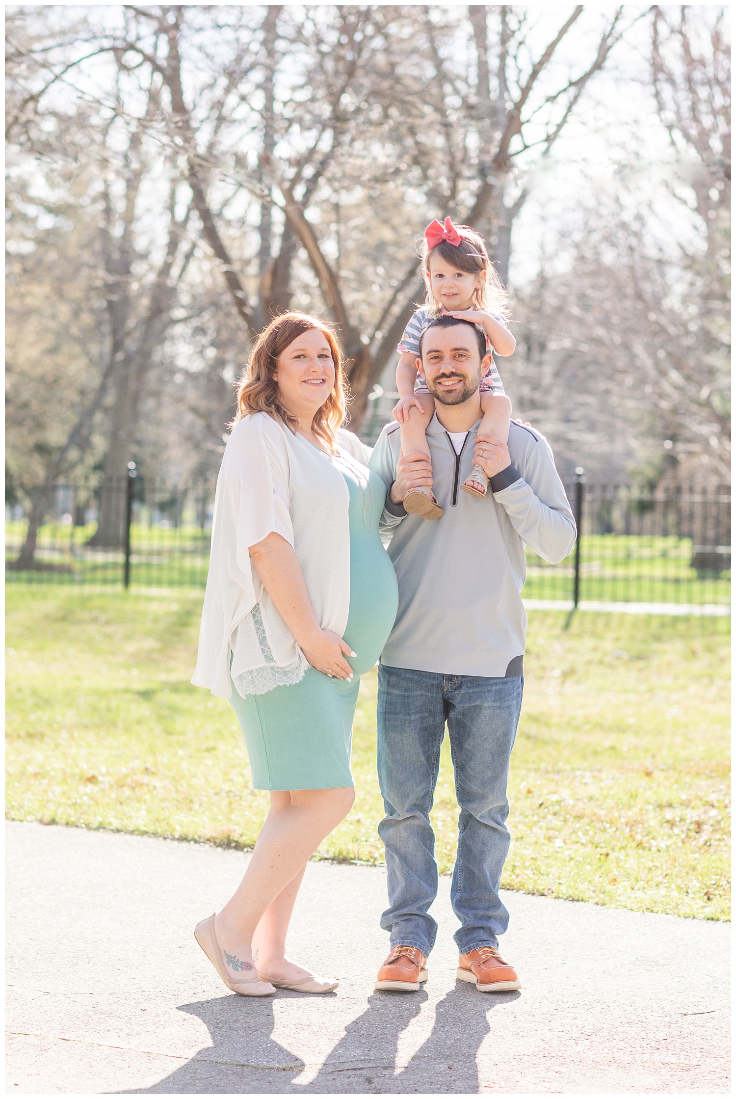 family standing together for maternity photos outside