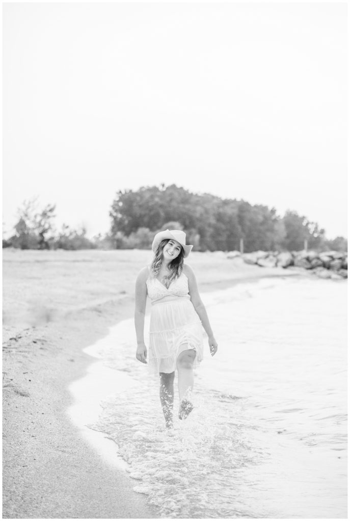 girl kicking the water at a lake in Ohio for senior photos