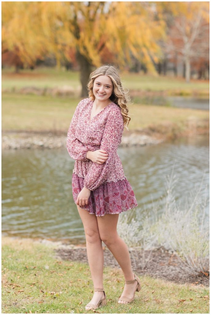 senior girl wearing a pink dress standing outside for photos