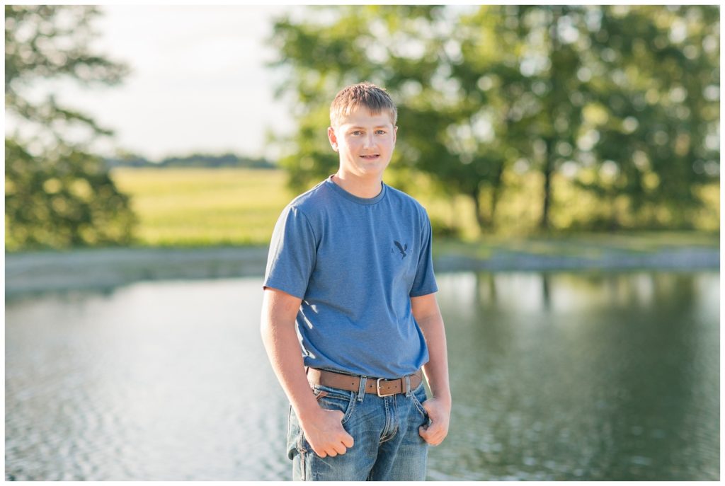 senior boy posing in front of a lake in Ohio