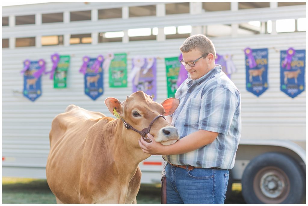 senior boy petting his cow on his family farm in Ohio