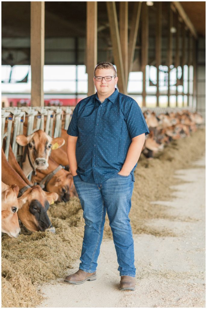 boy posing next to his cows on his family farm in Ohio