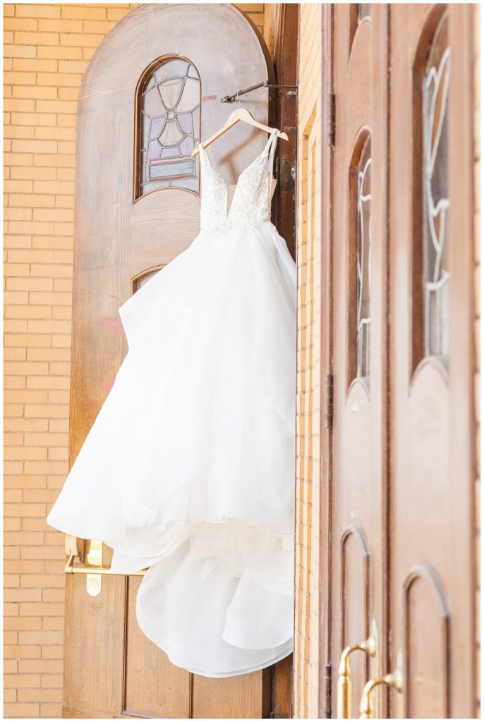 dress hanging from church doors in Ohio wedding