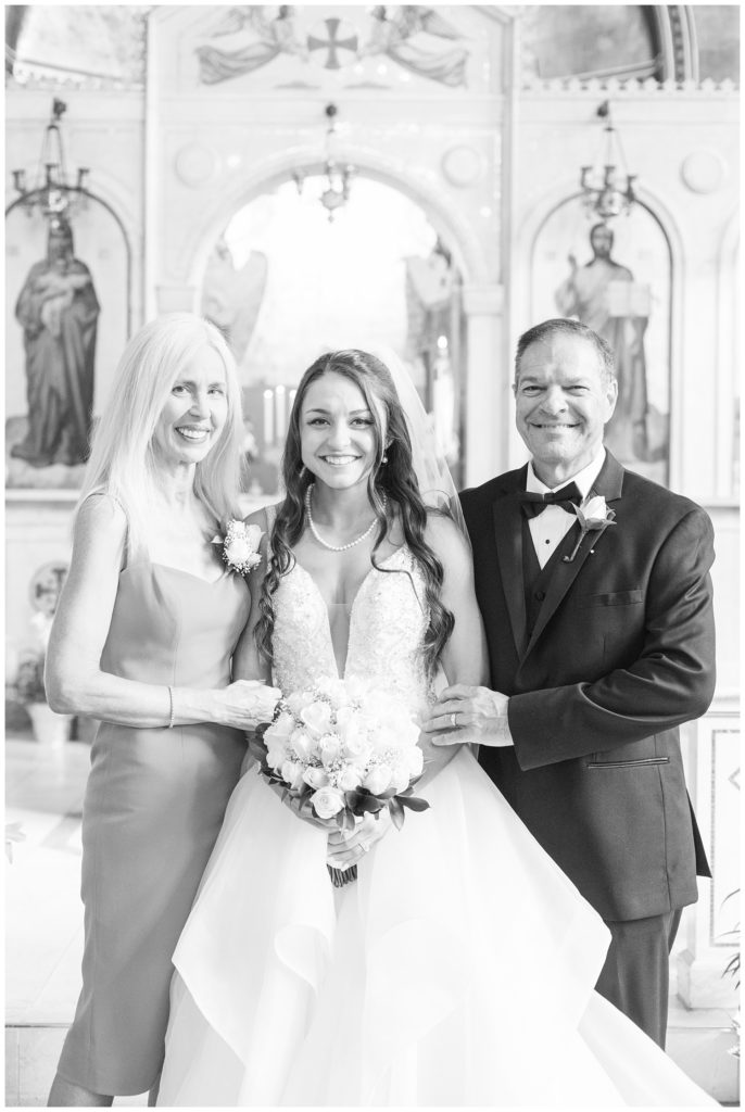 Bride with her mom and dad at Greek wedding ceremony