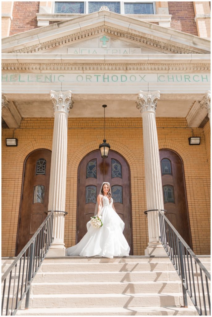 bride standing on the stairs at Greek orthodox church in Ohio
