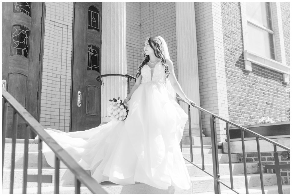 bride looking away standing on the stairs at Greek orthodox church