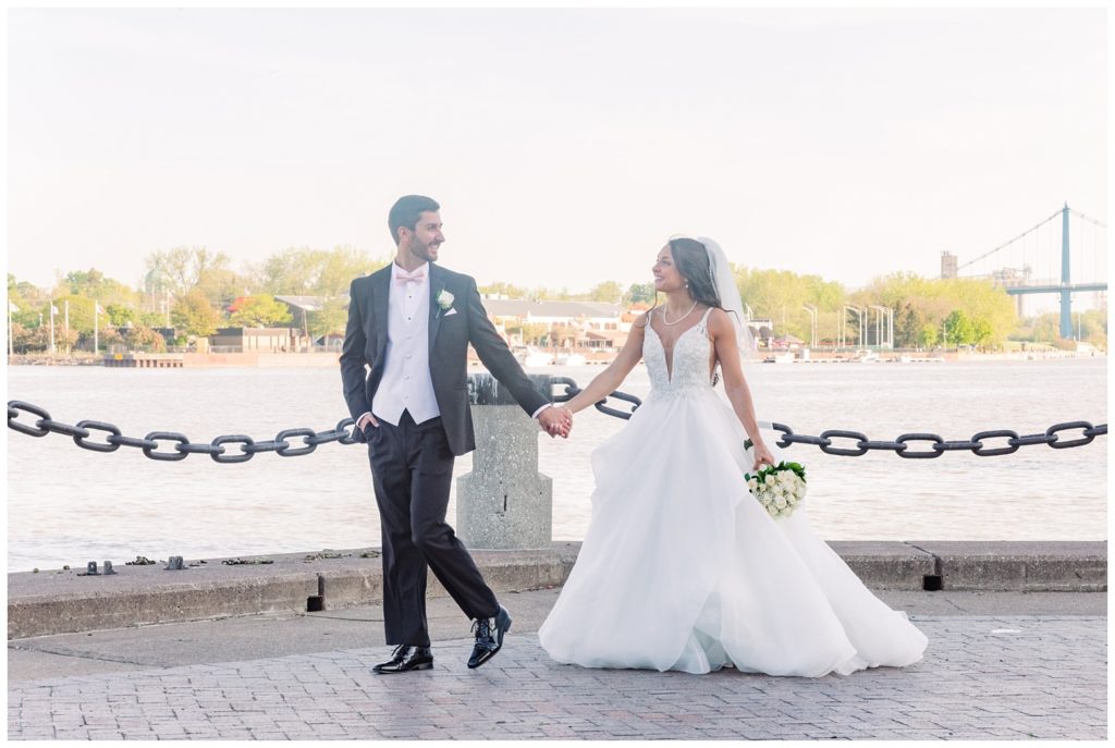 bride and groom walking together at pier in Toledo, Ohio