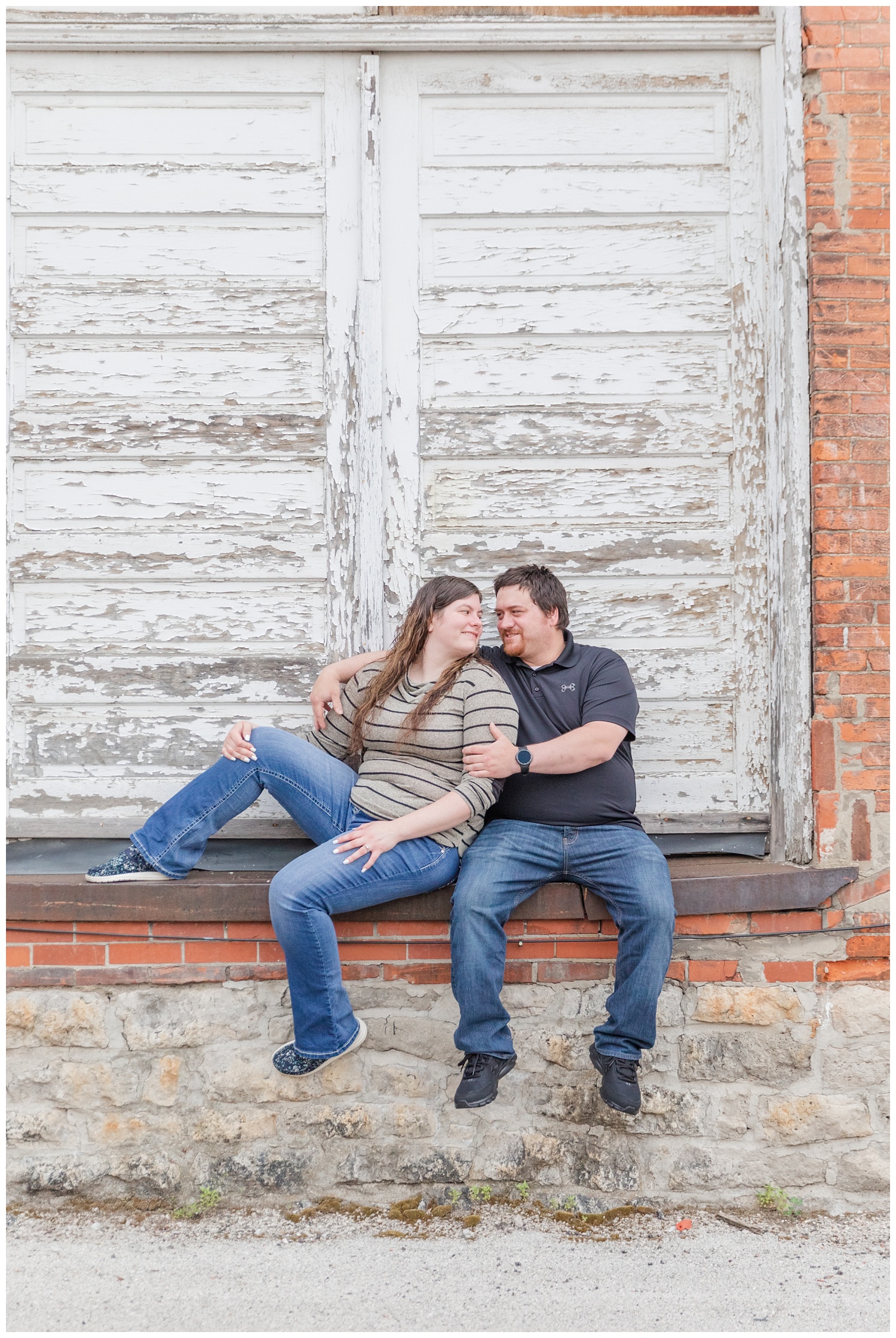 couple sitting next to a distressed white door 
