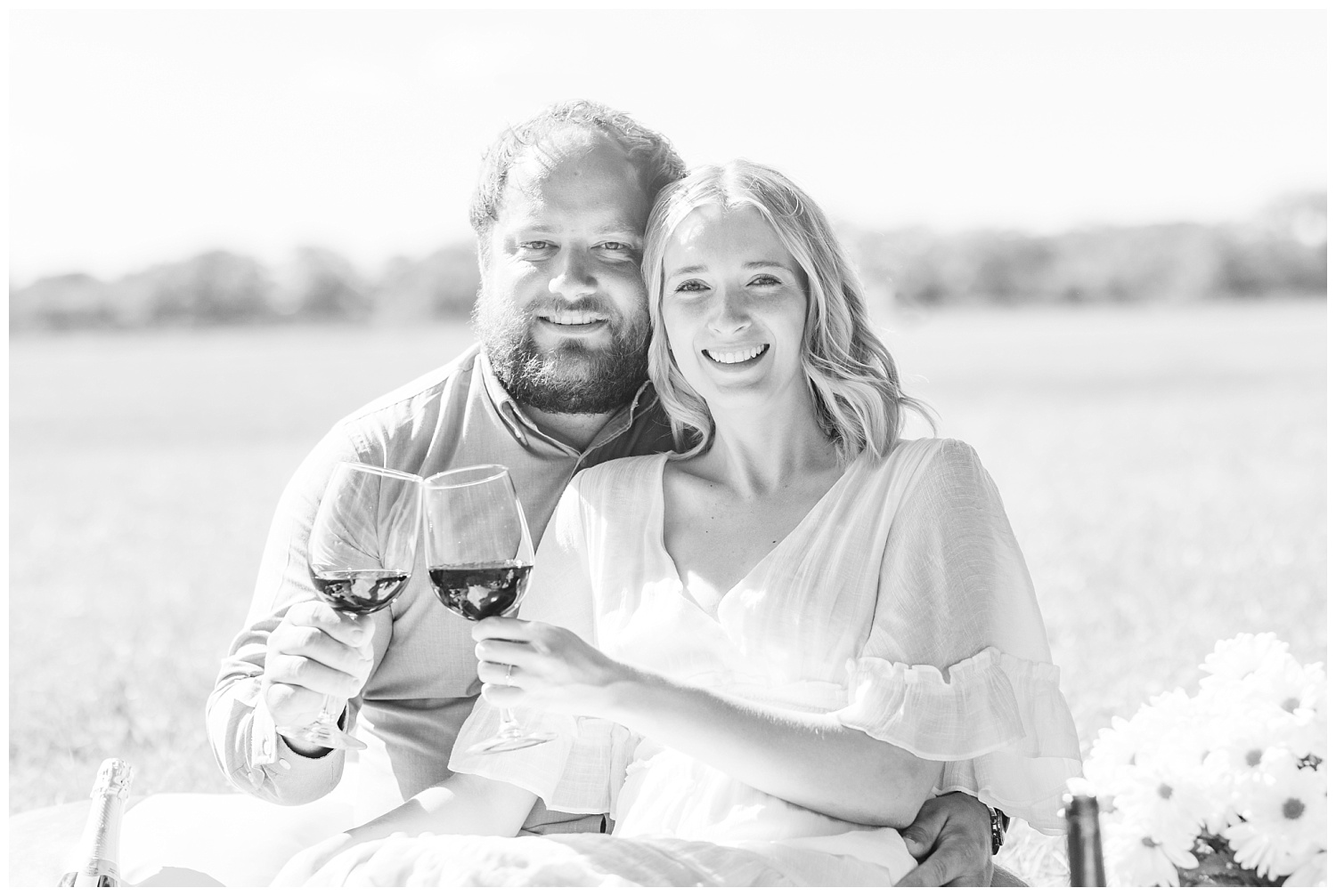 couple toasting with wine during engagement session in Fremont, Ohio