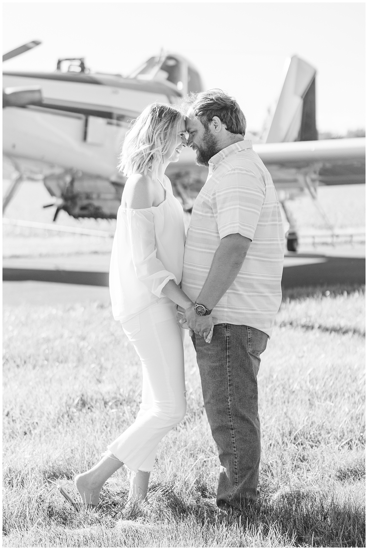 couple posing for engagement session in front an airplane