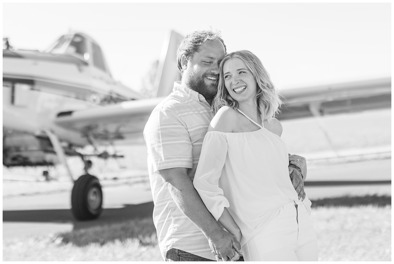couple laughing during airplane engagement session in Ohio