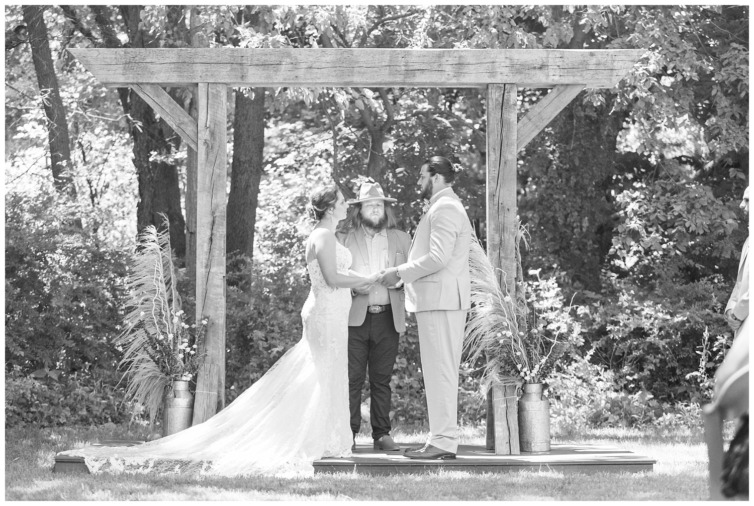 bride and groom exchange rings at outdoor ceremony