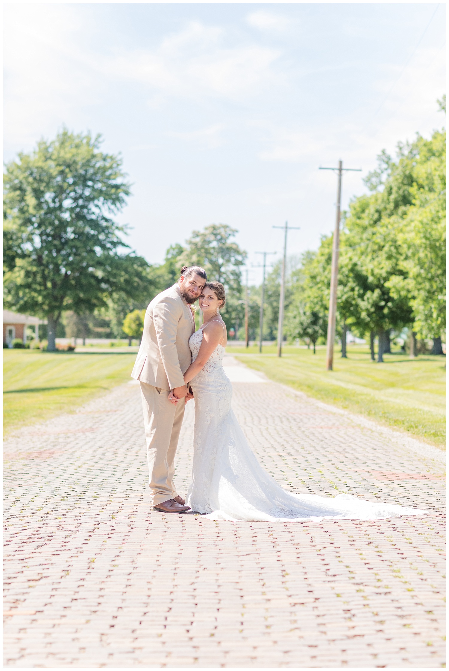 bride and groom touching heads on a brick street in Ohio