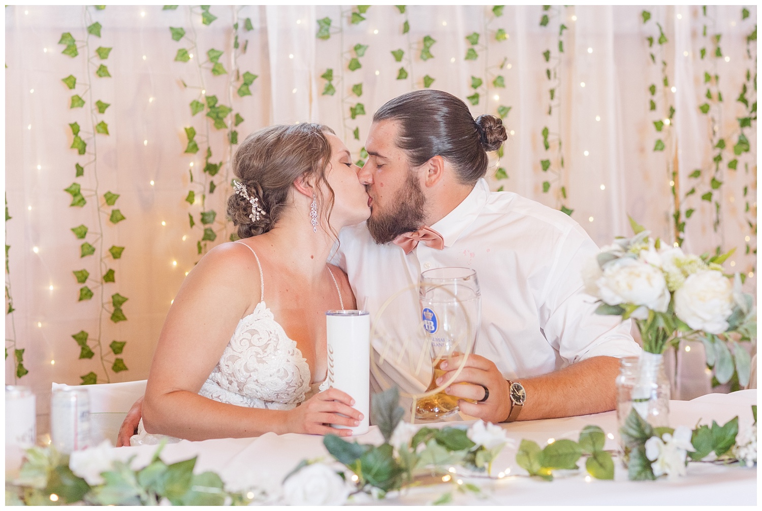 bride and groom kissing at a sweetheart table at reception