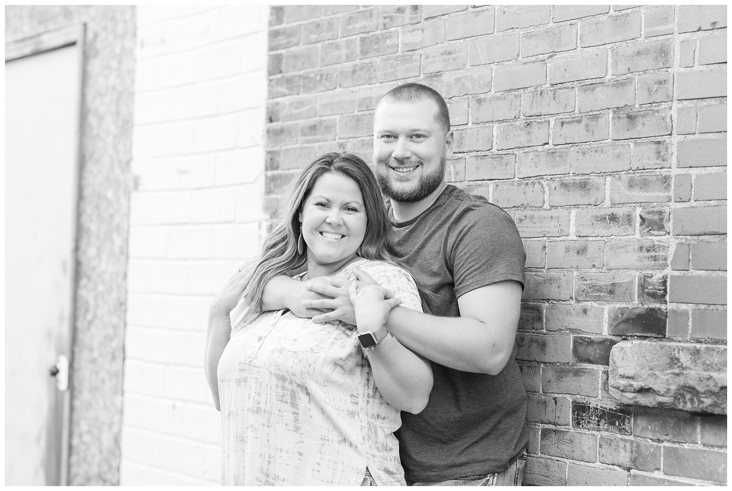 couple leaning against a brick wall in downtown Gibsonburg, Ohio