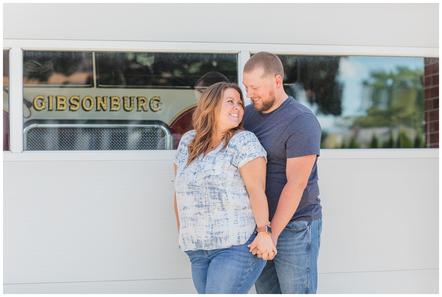 couple standing in front a fire station for engagement session in Ohio