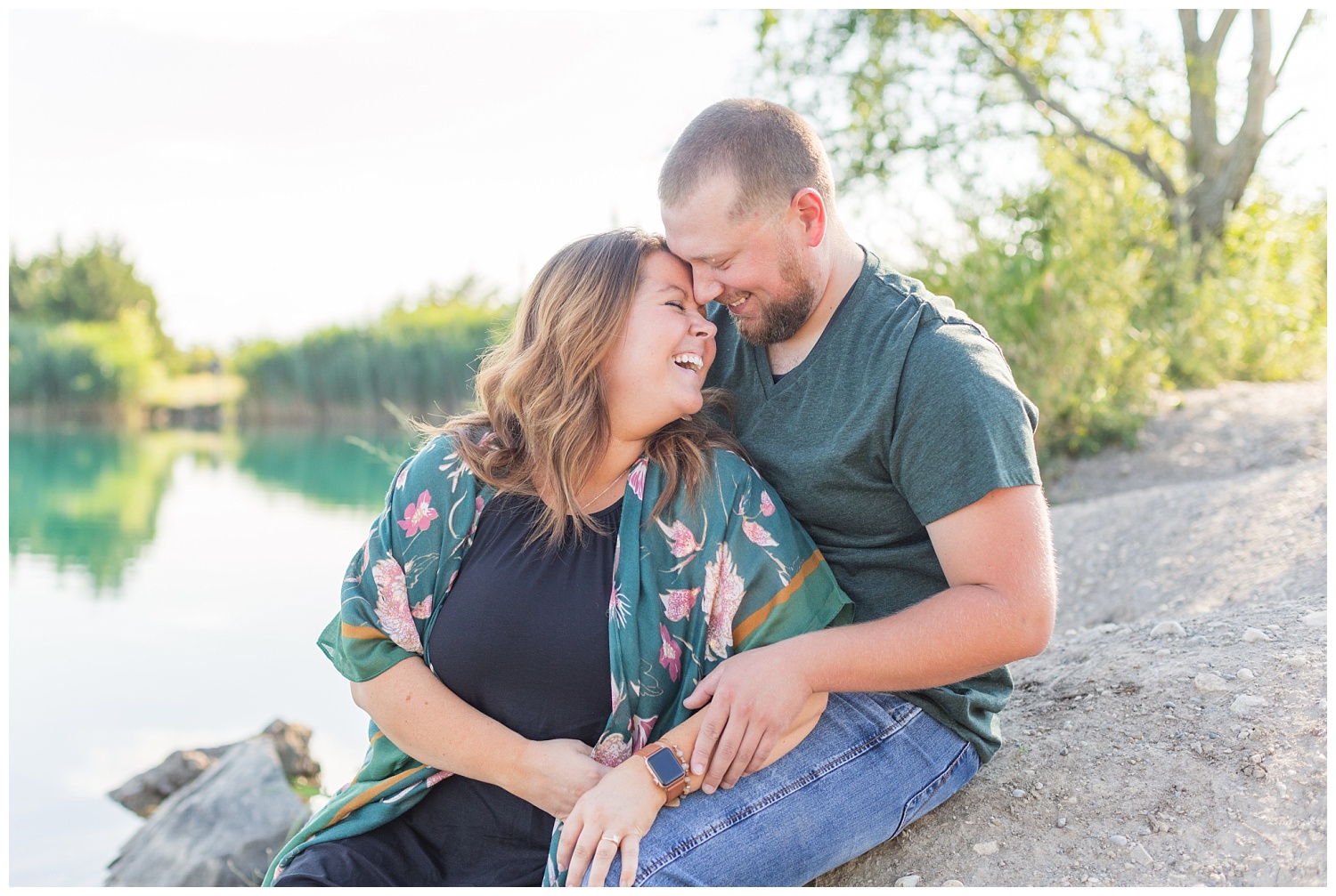 couple sitting on the rocks laughing during engagement session in Ohio
