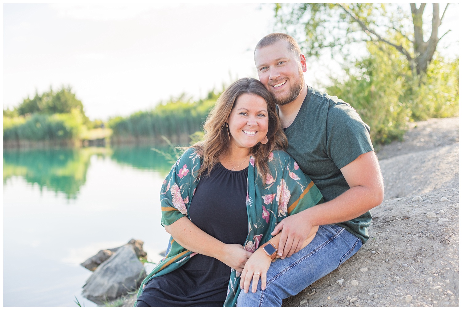 couple sitting on the rocks smiling for engagement session photos