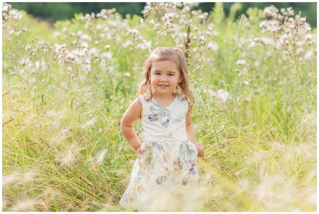little girl standing in a wheat field in Green Springs, Ohio