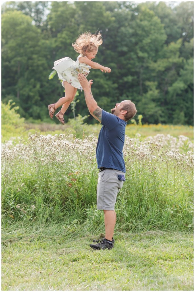 dad throwing his three year old daughter up in the air in Ohio