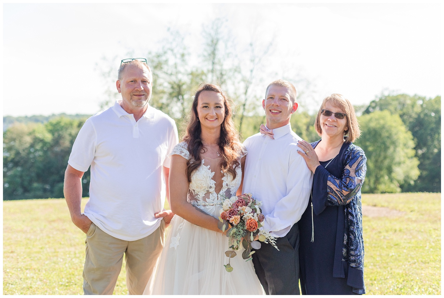 bride and groom posing with groom's parents at Ohio wedding