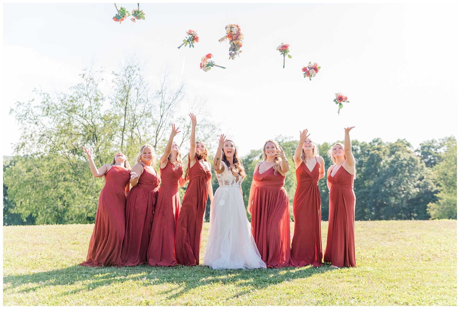 bridal party throwing their bouquets in the air at wedding