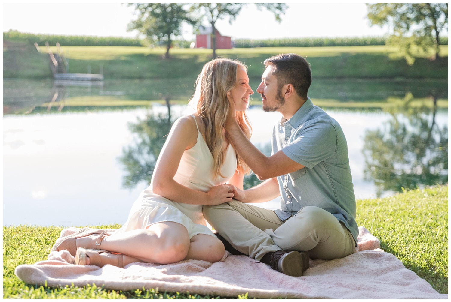 couple sitting on a blanket next to a pond in Green Springs