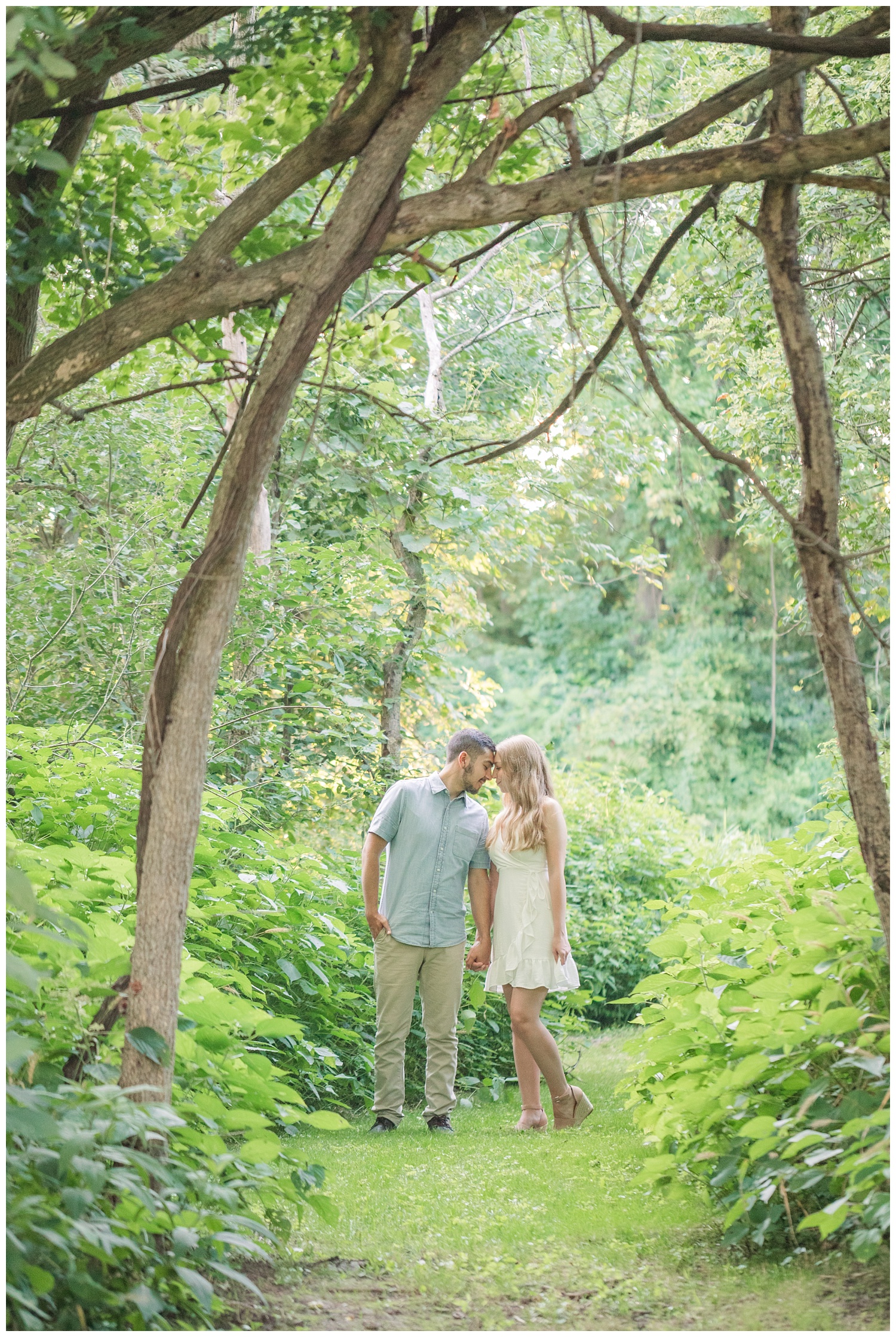 couple standing in the woods holding hands at Ohio engagement session