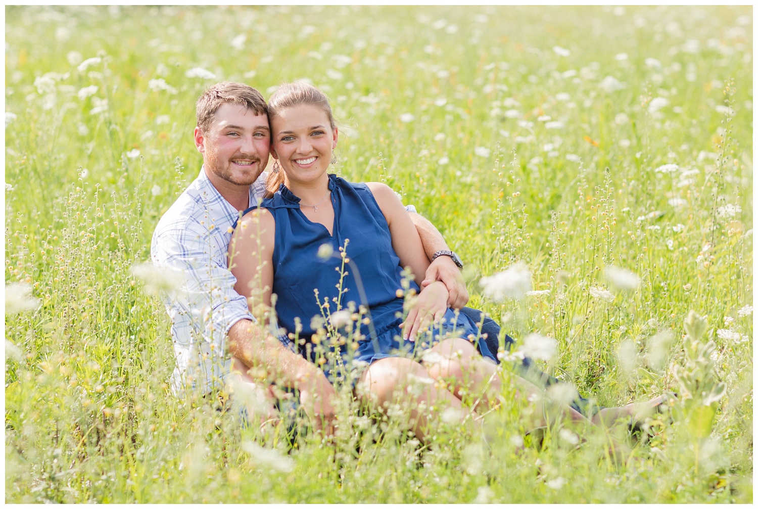 engaged couple sitting together in a flower field in Ohio