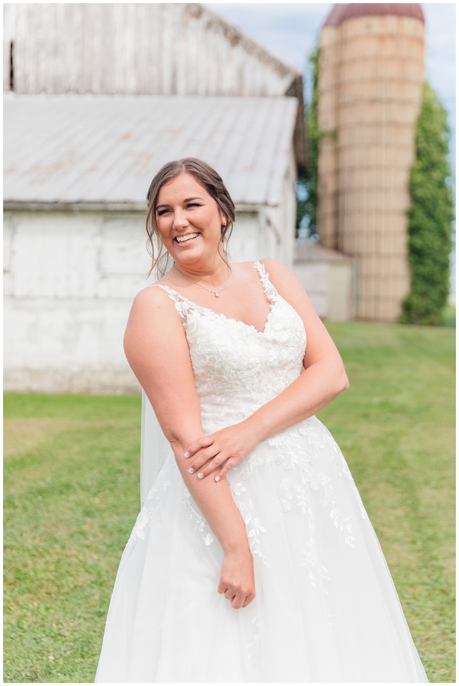 bride laughing in front of a white barn in Fremont, Ohio