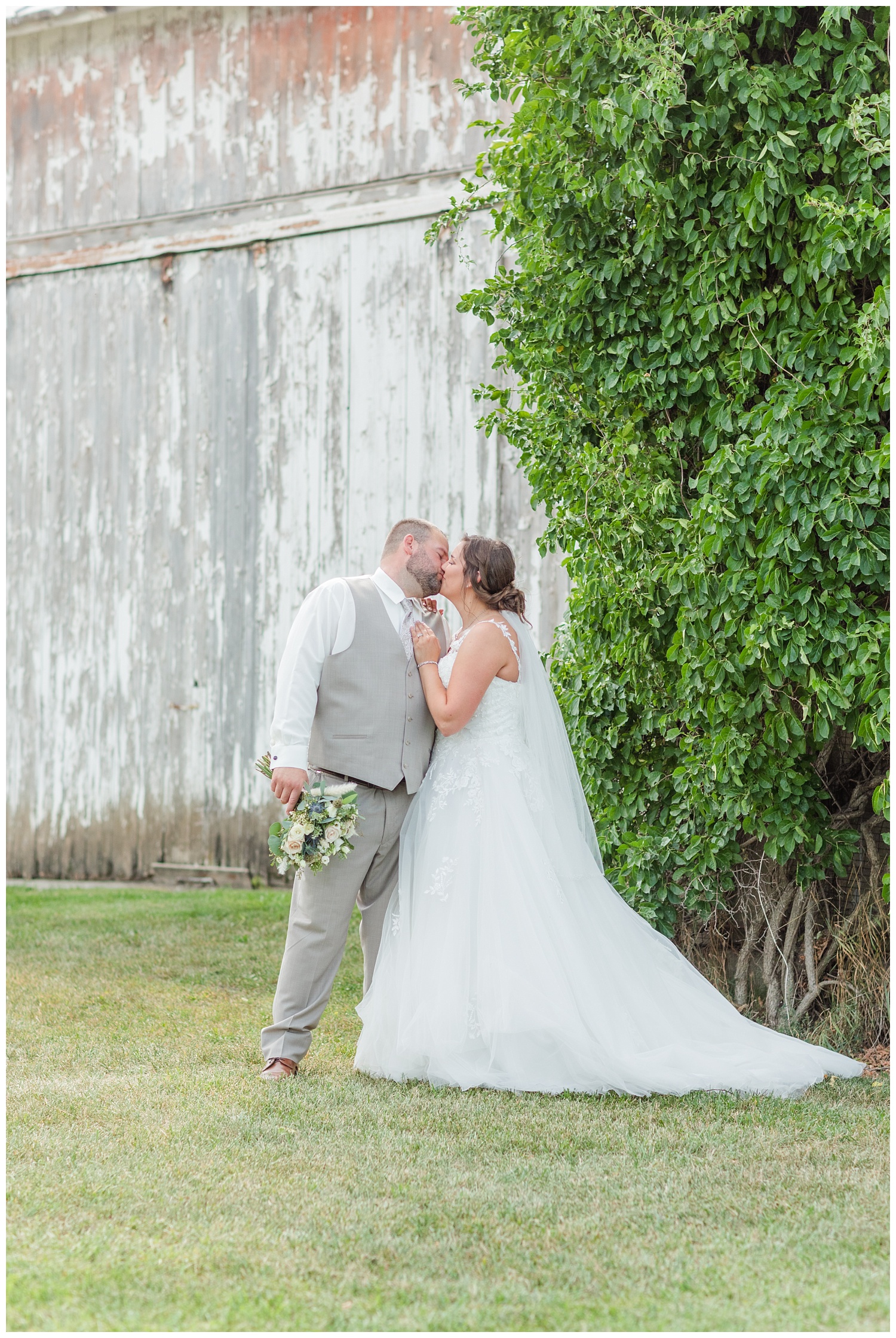 wedding couple kissing in front of a white barn in Fremont, Ohio