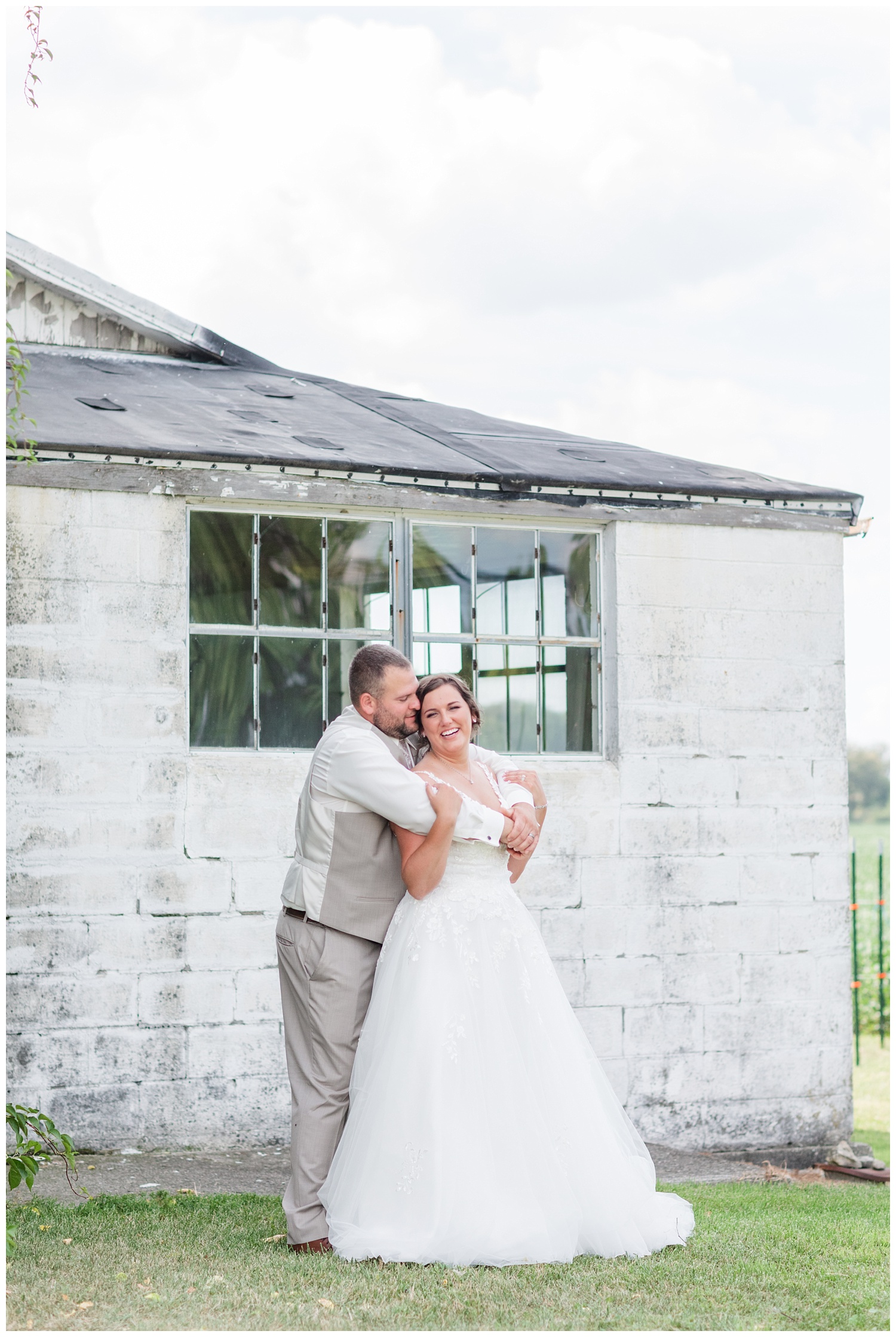 wedding couple posing in front of a white barn in Fremont, Ohio