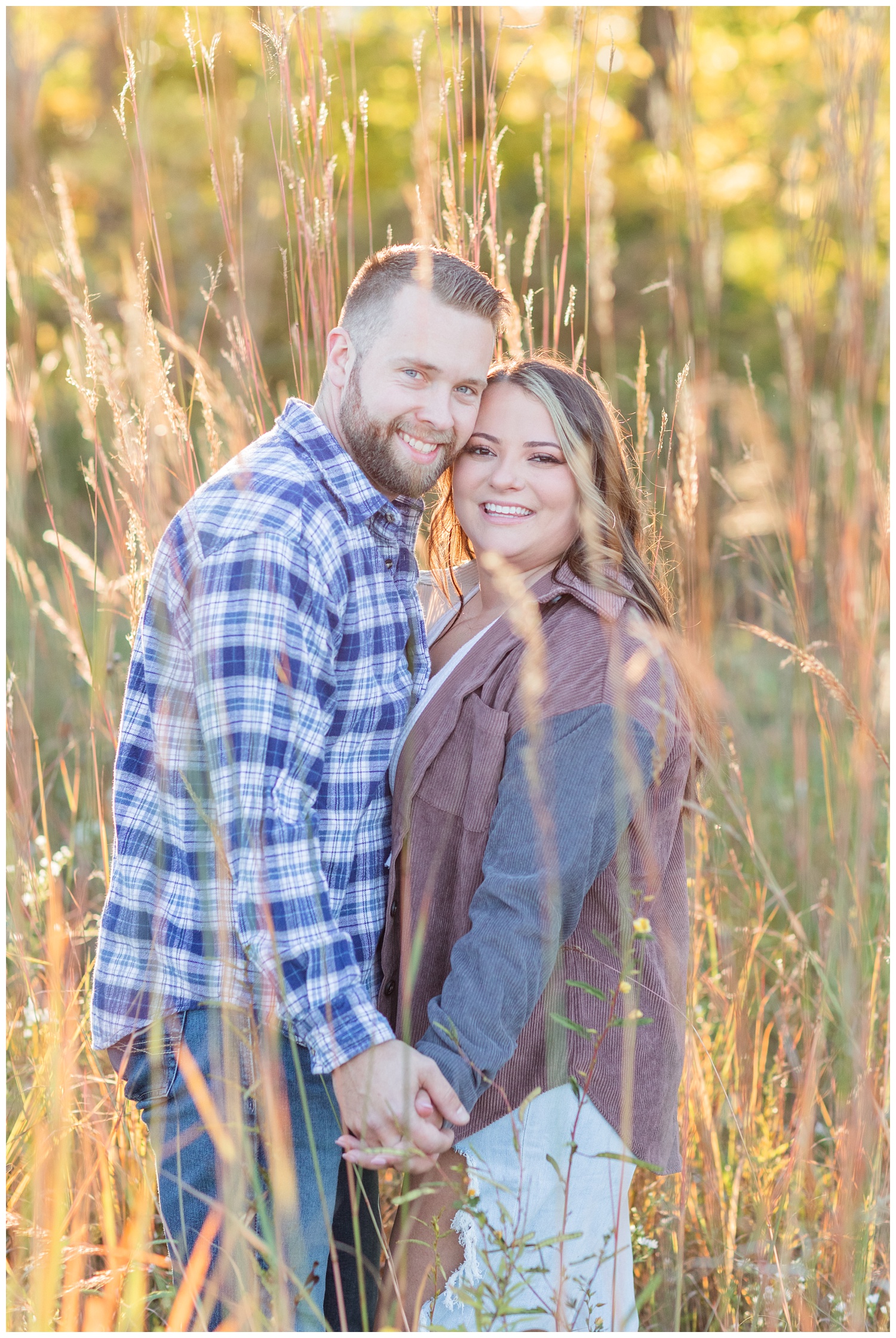 engaged couple standing in tall grass