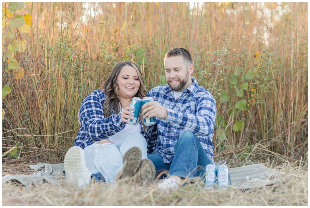 couple toasting with beers at Fremont, Ohio engagement session
