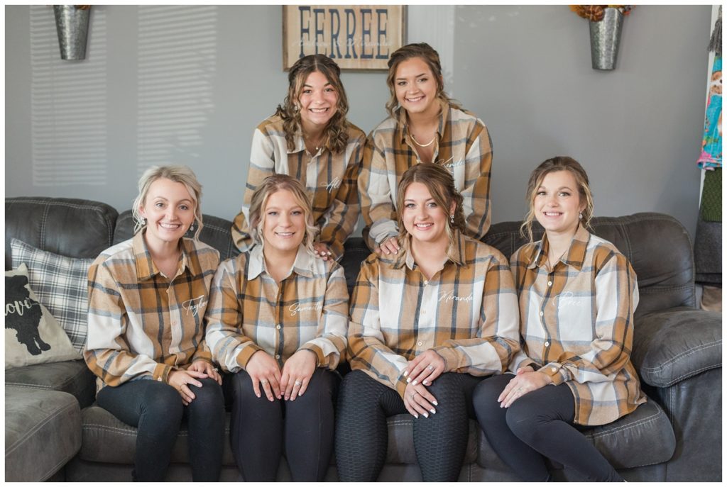 bride and bridesmaids wearing flannel shirts getting ready