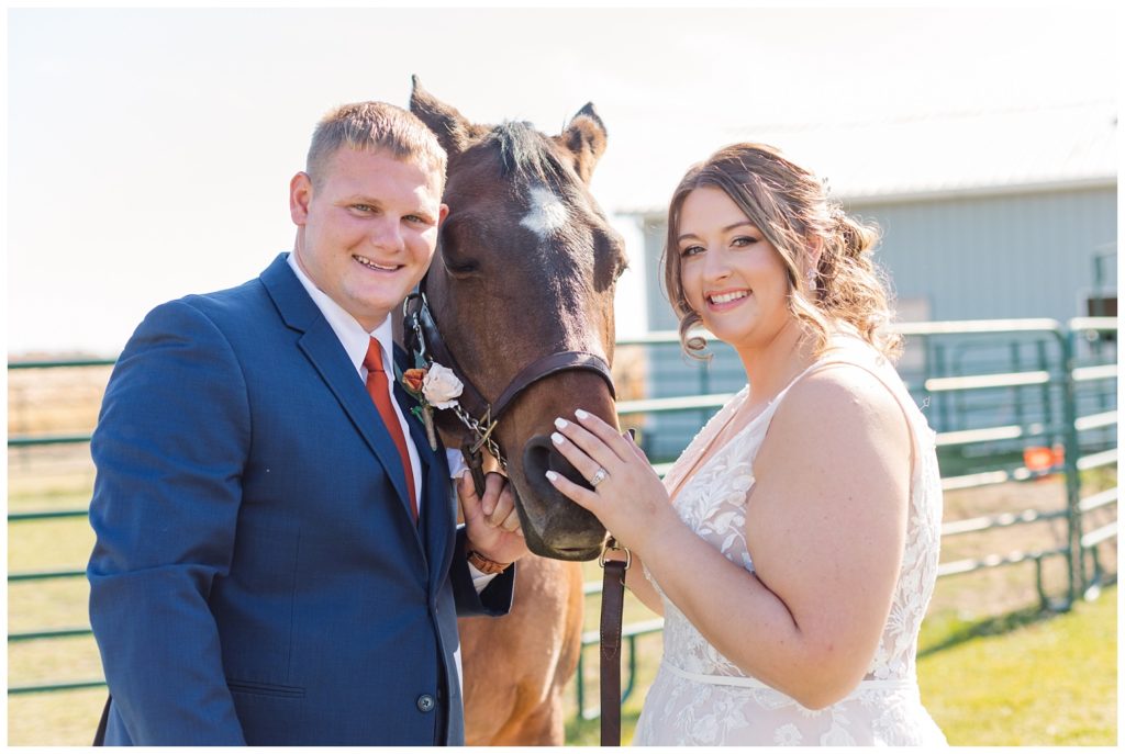bride and groom posing with horses before the wedding in Fostoria, Ohio