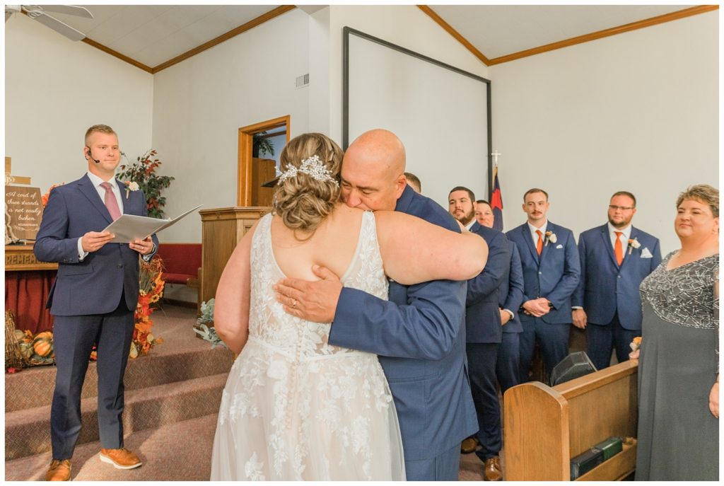 bride hugging her dad at church altar