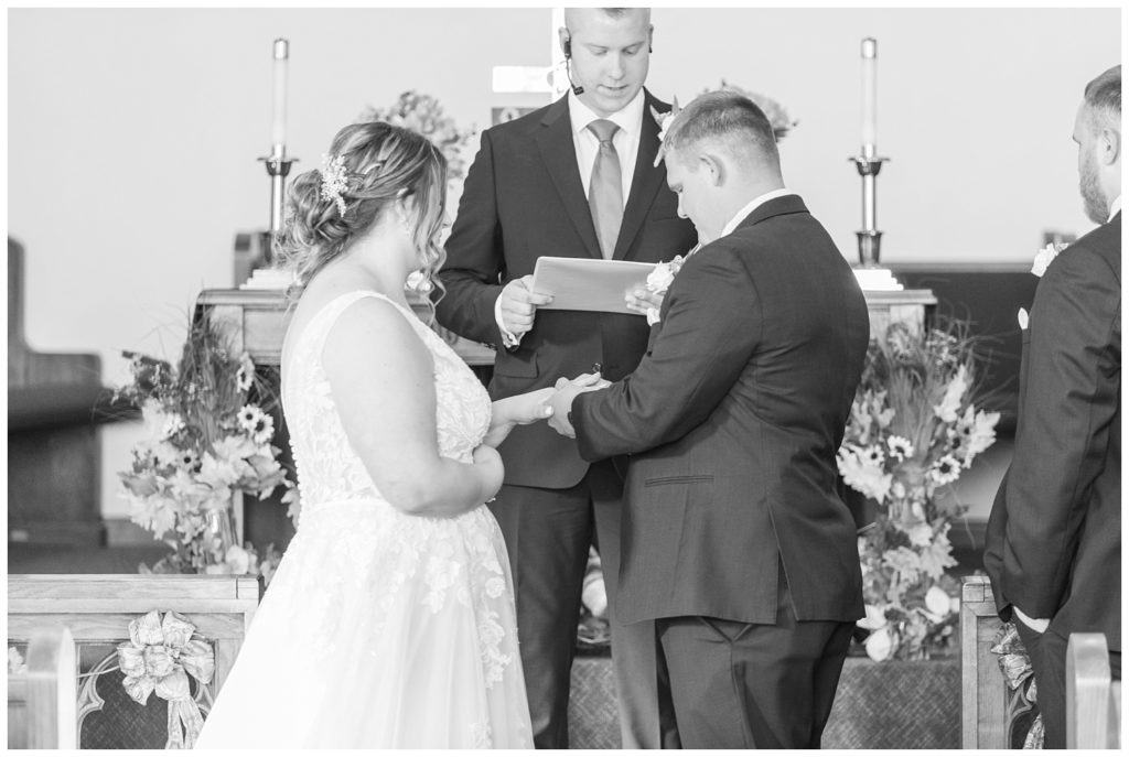 bride and groom exchanging rings at the altar