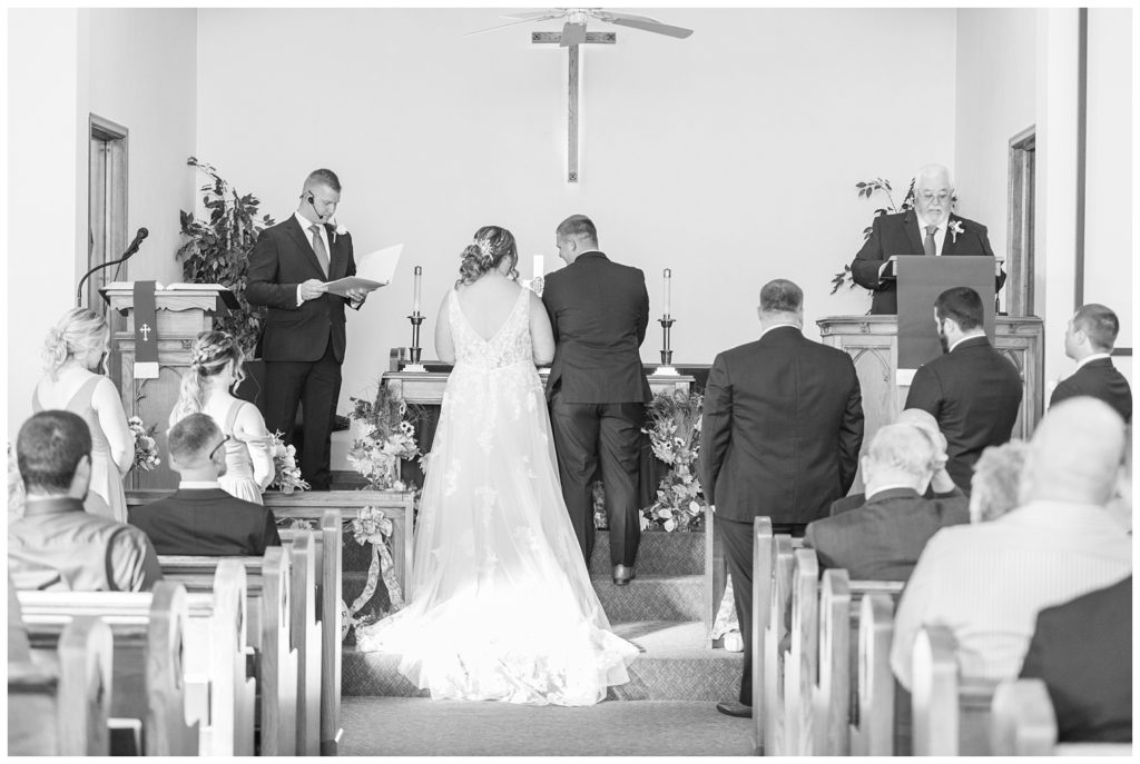 bride and groom kneeling at the altar at church in Fostoria, Ohio