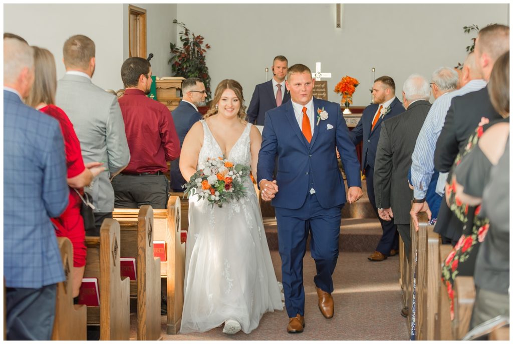 wedding couple walking back down the aisle after church ceremony