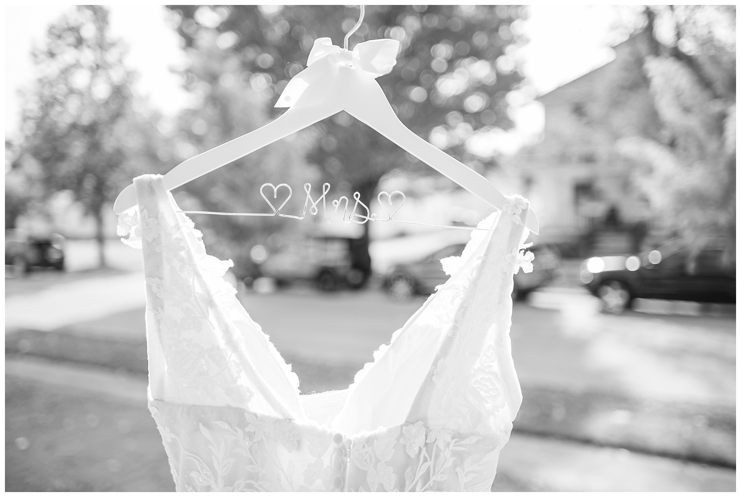 detail of wooden wedding hanger with lace dress 