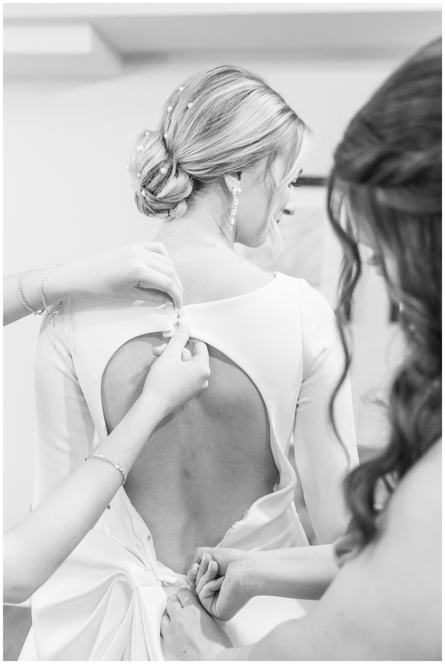 bridesmaids adjusting the bride's buttons