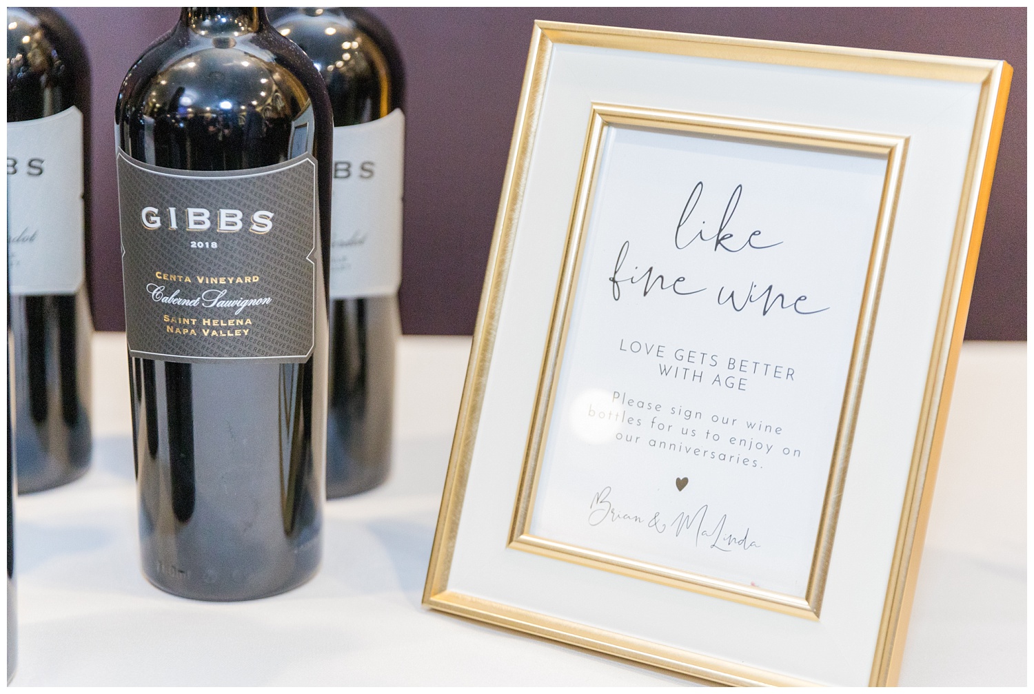 bottles of Gibbs wine next to a framed sign at winter wedding reception