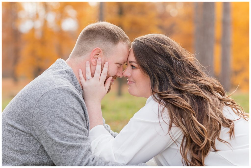 couple touching foreheads in the grass at northwest Ohio engagement session