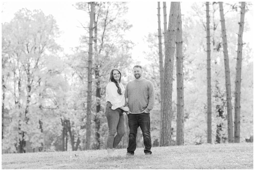couple standing together at trees at Norwalk Reservoir engagement session