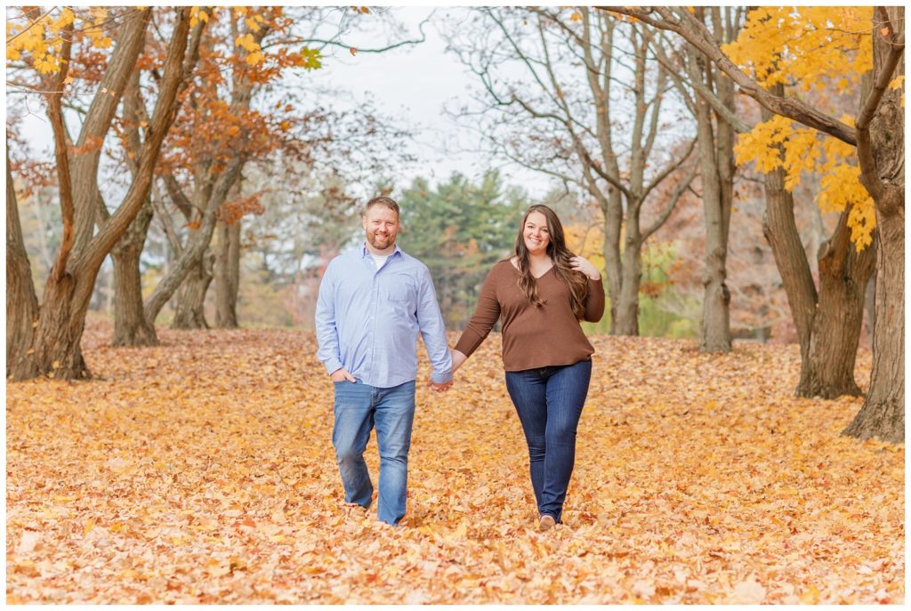 couple walking on orange and yellow leaves at Norwalk Reservoir in Ohio
